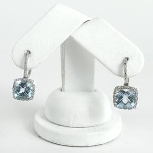 Silver earrings with blue gemstone pendants.