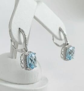 Silver earrings with blue gemstones displayed.