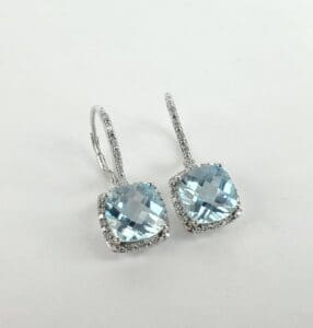 Silver earrings with blue gemstone squares.