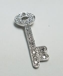 Silver key decorated with sparkling gemstones.