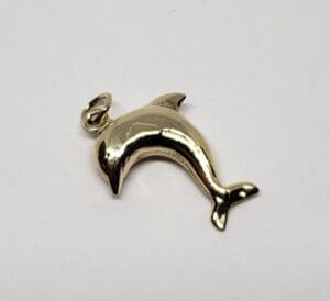 Gold dolphin pendant on white background.