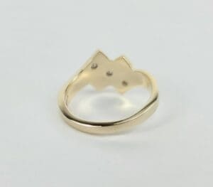 Gold ring with crown-shaped design.