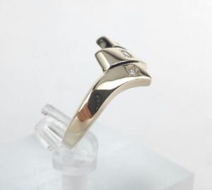 Gold ring with diamond on display stand.