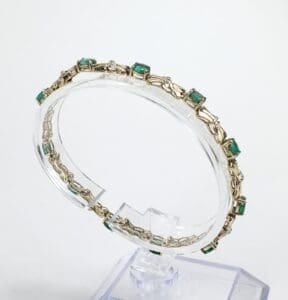 Gold bracelet with green gemstone accents.