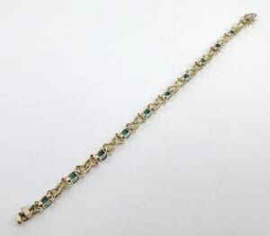 Gold bracelet with green gemstone accents.