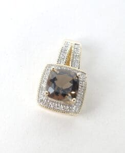 Gold pendant with square brown gemstone.