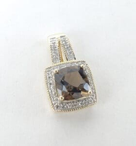 Gold pendant with brown and clear stones.