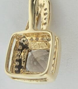Gold pendant with clear gemstone detail.