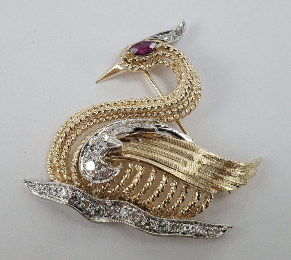 Gold and silver bird-shaped brooch.