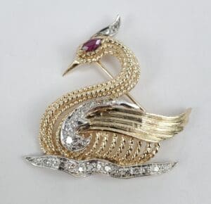 Gold and silver bird brooch with gemstones.
