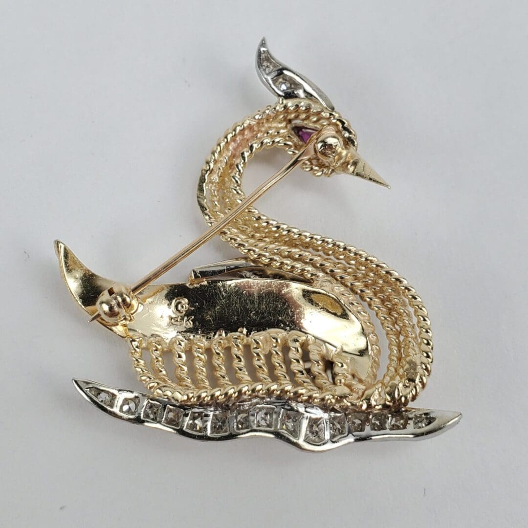 Gold dragon-shaped brooch with gemstones.