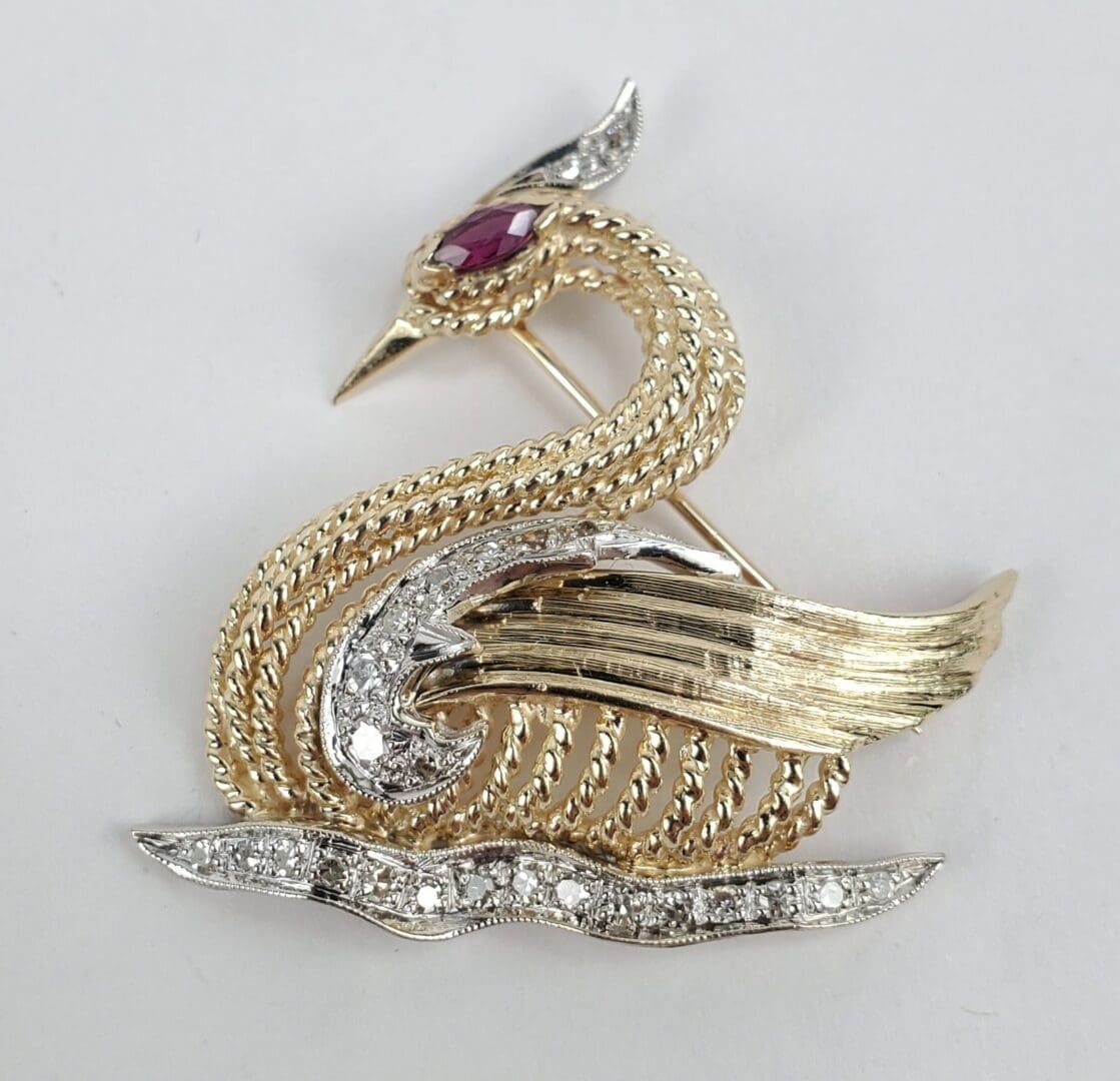 Gold and silver bird brooch with gemstones.