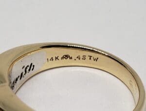 Gold ring with engraved specifications inside.