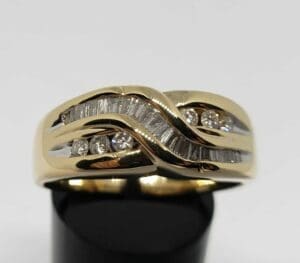 Gold ring with diamonds on display stand.