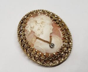 Ornate cameo brooch with filigree border.