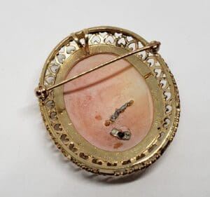 Gold vintage brooch with intricate design.