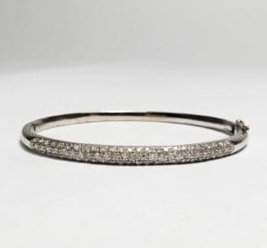 Silver bracelet with embedded diamonds on display.