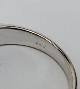 Silver ring with engraved markings on inside.