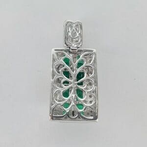 Silver pendant with green gemstone inlay.