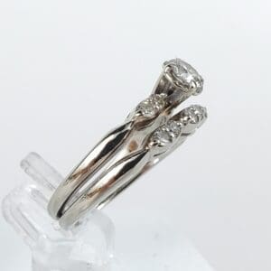 Silver ring with diamond accents displayed vertically.