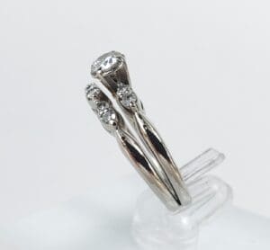 Silver ring with multiple small diamonds displayed.