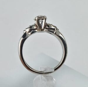 Silver ring with three diamonds on display.