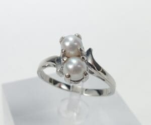 Silver ring with two pearl settings.