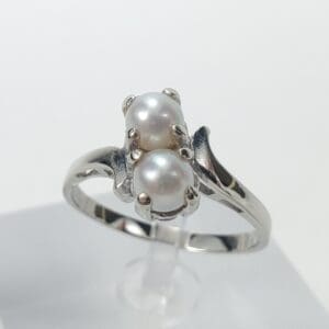Silver ring with two pearl settings.