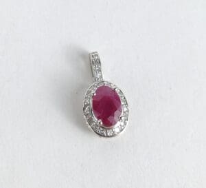 Silver pendant with oval red gemstone.
