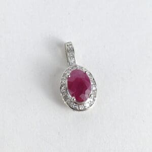 Silver pendant with oval red gemstone.