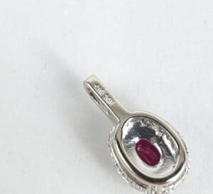 Silver pendant with red gemstone inlay.