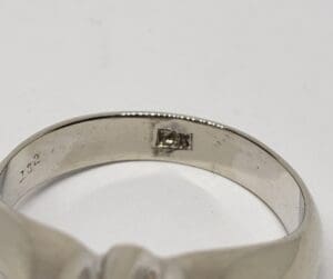 Silver ring with engraved markings inside band.