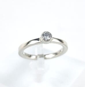 Silver ring with a single round diamond.