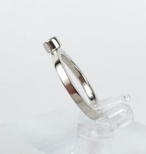 Silver ring on clear display stand.