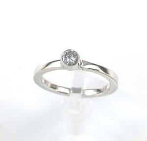 Silver ring with a single round diamond.