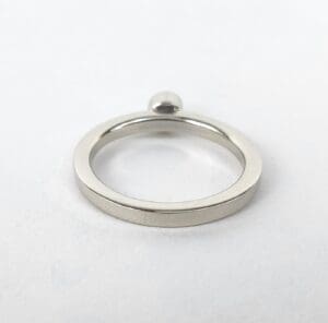 Silver ring with small round accent.