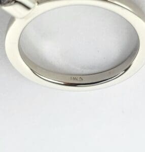 Silver ring with engraved markings.