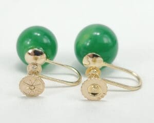 Gold and green gemstone cufflinks on display.