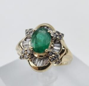 Gold ring with emerald and diamond accents.