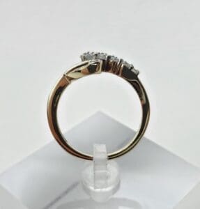 Gold ring with diamonds on display stand.