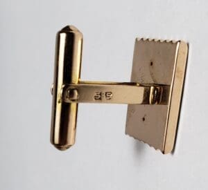 Gold cufflink with engraved numbers 3-5.