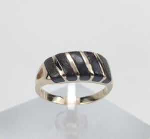 Gold ring with black striped design.