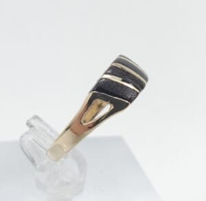 Gold and black ring on display stand.