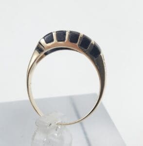Gold ring with black rectangular inlays.