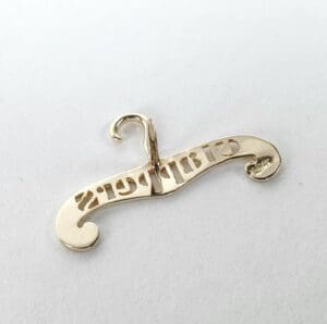 Gold hanger pendant with engraved text.