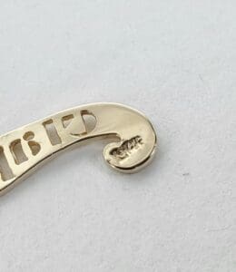 Gold metal piece with engraved details.