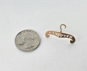 Tiny hanger beside a 1964 quarter coin.