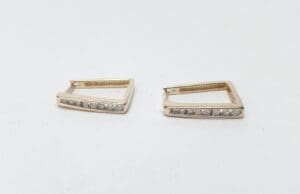 Gold square earrings with small diamonds.