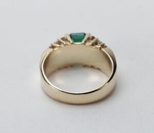 Gold ring with green gemstone detail.