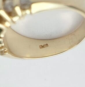 Gold ring with engraved hallmark inside band.